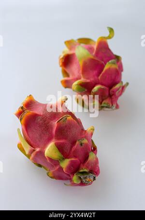 Two ripe pitaya fruits or dragon fruit on a light background. Close up. Vertical crop. Stock Photo