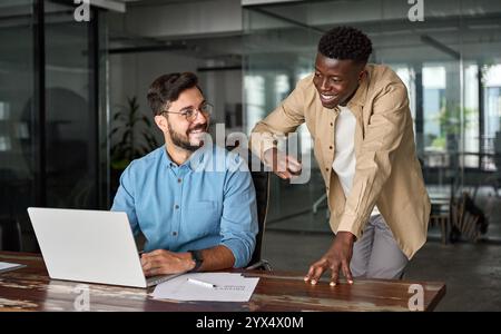 Two busy happy diverse professional coworkers discussing project at work.. Stock Photo