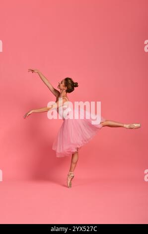 Ballerina in a pink tutu performing a classical pose on pointe. Concept: grace, femininity, and elegance in ballet Stock Photo
