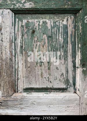 Fragment of an old wooden door with peeling paint. Close-up Stock Photo