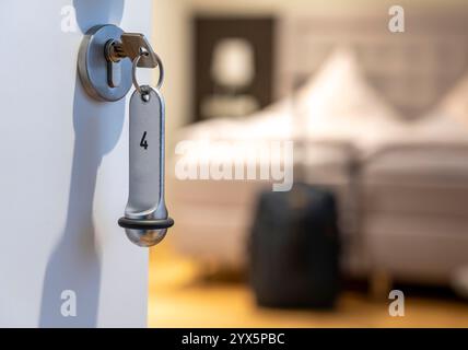 Symbolic image of a hotel, key in the door of a hotel room, analogue lock, Stock Photo