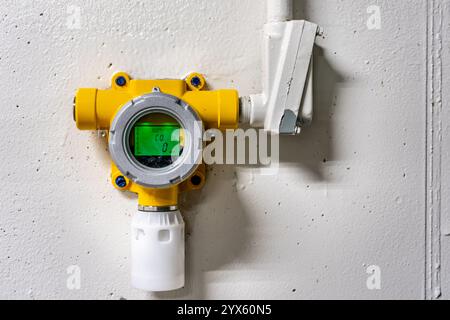 Yellow wall mounted industrial carbon monoxide gas monitoring detector, device in an industrial waste water treatment environment. Stock Photo