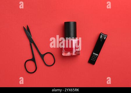 Set of pedicure tools on red background, flat lay Stock Photo