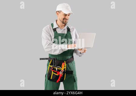 Male technician using laptop on light background Stock Photo