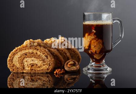 Dessert with walnuts and coffee latte on a black reflective background. Cake with brown sugar, walnuts, and cream. Copy space. Stock Photo