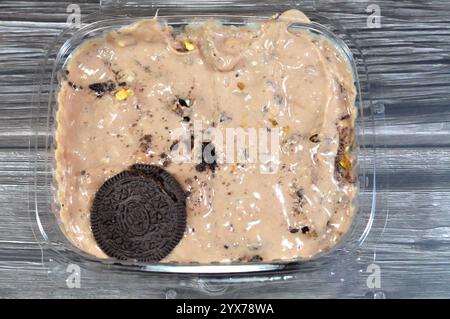 Creamy cold cookie pieces with a sweet fondant filling with whipped cream and chocolate ice cream, with pieces of cocoa biscuits, summertime and holid Stock Photo