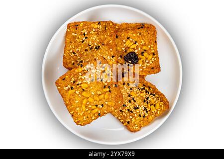 Top view of square shape bars of crispy homemade multigrain  rice cracker in white ceramic dish isolated on white background with clipping path. Stock Photo