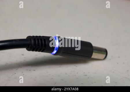 AC Adapter plug with blue LED power indicator ring Stock Photo