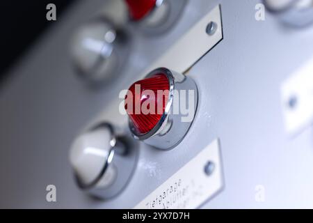 Close-up of a white and red signal lamp. Close-up of a white and red signal lamp on a power distributor of a heating system. Analog device, electrical equipment, control panel technology. obj switchboard control light B97A8085 Stock Photo