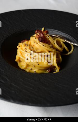 Spaghetti Carbonara Roman Style Italian Pasta with an Egg and Cheese Sauce, Topped with Guanciale Bacon Stock Photo