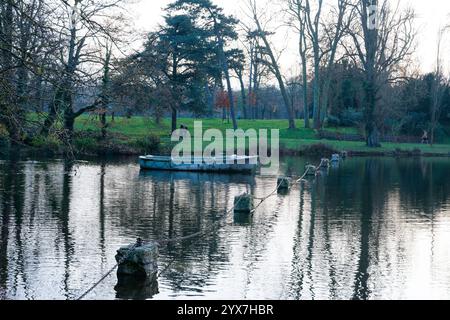 Tranquil afternoon in Bois de Vincennes with reflective waters and a solitary boat Stock Photo