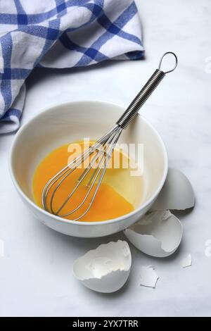 Whipped egg in shell with whisk, egg shells Stock Photo