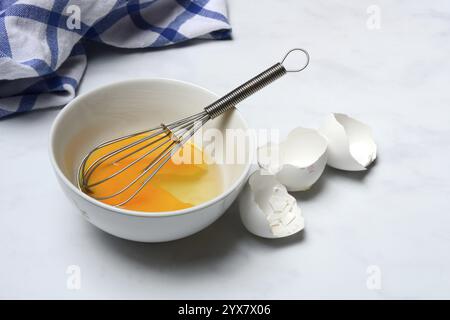 Whipped egg in shell with whisk, egg shells Stock Photo