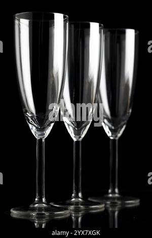 Three empty champagne glasses against a black background Stock Photo