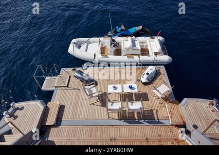 Luxury Yacht Swimming Deck Overlooking a Calm Sea with a Docked Inflatable Boat and JetSki Stock Photo