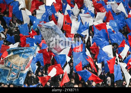 Union Bears, a group of Rangers FC football supporters, waving red, white and blue plastic flags in Ibrox stadium, before the football match started. Stock Photo