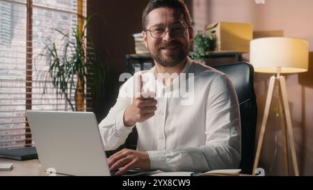 Happy cheerful Caucasian male man businessman manager executive work type laptop in office worker developer boss showing thumb up gesture corporate Stock Photo