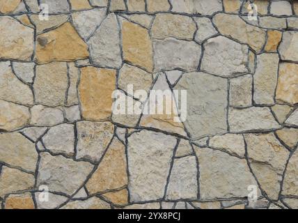 cladding the surface with decorative stone of abstract shape of gray and brown color with dark seams at the junction, beautiful stone tiles Stock Photo