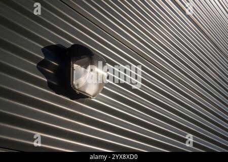 industrial lamp on outside of a metal corrugated warehouse building Stock Photo