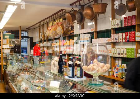 Cremona, Italy - November 15th 2020 Variety of italian cured meats, cheeses, wines, and packaged goods displayed in a traditional delicatessen in crem Stock Photo