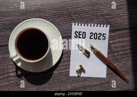 Seo handwritten with white chalk on a blackboard, cup of coffee and biscuit on a wooden background Stock Photo
