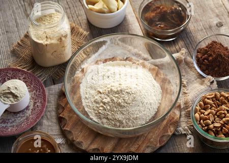 Ingredients for homemade protein chocolate bars - soaked dates, peanuts, raw cacao and whey protein powder in a bowl Stock Photo
