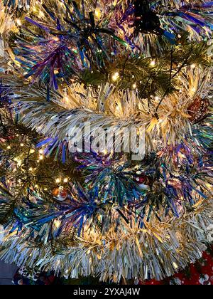 Christmas tree decorated with sparkly tinsel decorations. Close up. Stock Photo