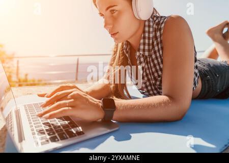 Woman Using Laptop Outdoors Wearing Headphones Stock Photo