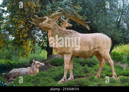 Large deer among dinosaur statues in Crystal Palace Park, London Stock Photo