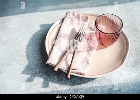 Close-up of a simple pink place setting on a table in sunlight Stock Photo