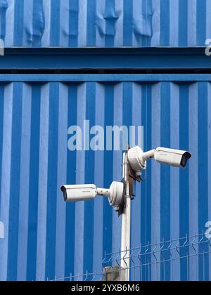 Security cameras on building site against blue shipping container (demolition of old Royal Liverpool Hospital) Stock Photo