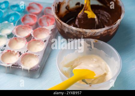 The process of making handmade chocolates. A candy mold with colorful dyes and bowls with white and dark chocolate. High quality photo Stock Photo