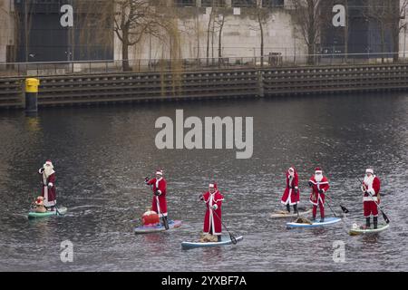 Water sports enthusiasts dressed as Santas ride SUPs on the Spree in Berlin on 14 December 2024 Stock Photo