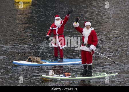 Water sports enthusiasts dressed as Santas ride SUPs on the Spree in Berlin on 14 December 2024 Stock Photo