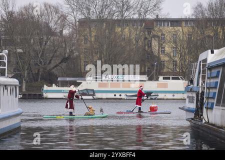 Water sports enthusiasts dressed as Santas ride SUPs on the Spree in Berlin on 14 December 2024 Stock Photo