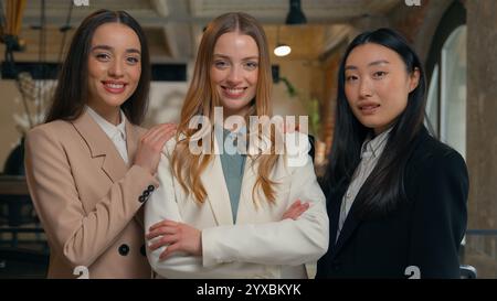 Three diversity business women girls multiracial female multiethnic businesswomen Asian Korean Caucasian colleagues co-workers in office ladies Stock Photo