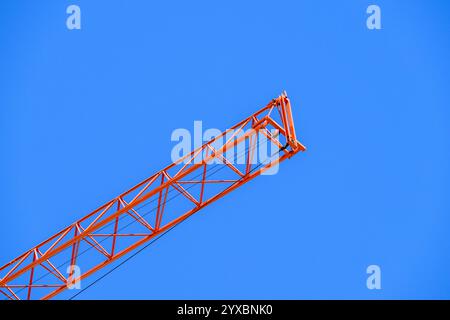 Red Construction crane against a blue sky Stock Photo