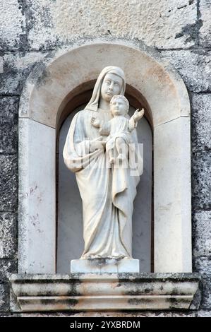 Virgin Mary with baby Jesus, statue on the portal of the chapel of Our Lady of Mercy in Vela Luka, Korcula island, Croatia Stock Photo