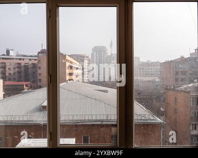 view through home window glass on city on smog winter day Stock Photo