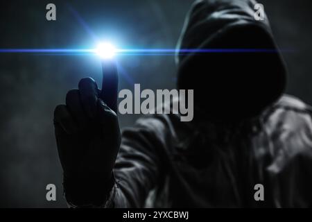 Computer hacker in hoodie using virtual screen. Database hacking, computer virus malware and cybersecurity concept. Selective focus. Stock Photo