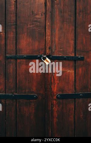 Old wooden gate locked with padlock, vertical image Stock Photo