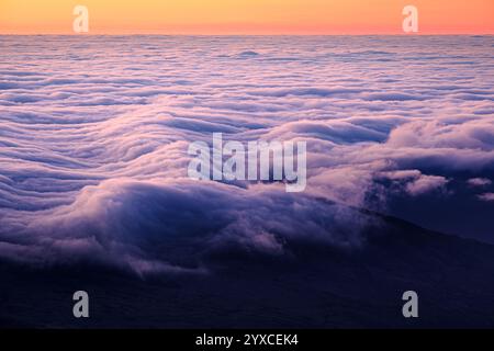 Colorful sunrise sky with dramatic waves of clouds over coastline Stock Photo