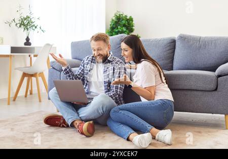 Happy Married Couple Using Laptop For Online Entertainment At Home Stock Photo