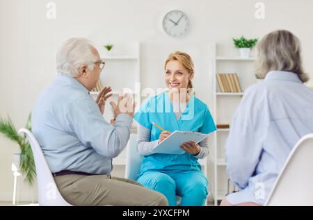 Senior people care, communication, young kind nurse, geriatric medicine caretaker talking to old Stock Photo