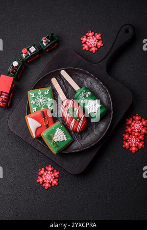 Natural popsicle ice cream on a stick covered with chocolate in the style and colors of Christmas and New Year on a dark concrete background Stock Photo