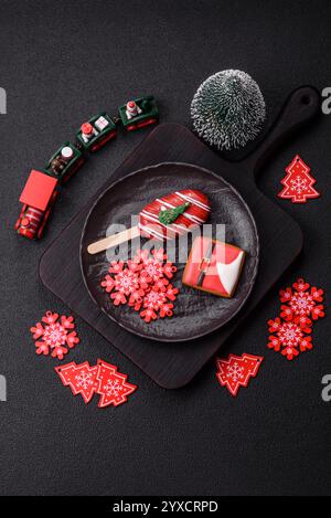 Natural popsicle ice cream on a stick covered with chocolate in the style and colors of Christmas and New Year on a dark concrete background Stock Photo