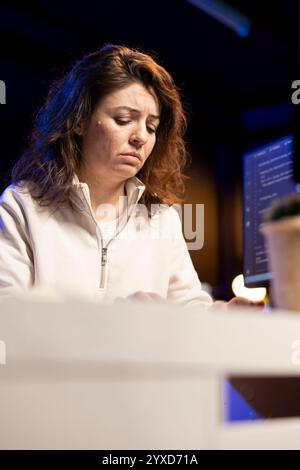 Sad system administrator pouting in frustration while doing software quality assurance, finding errors. Upset IT staff member inspecting coding on PC and seeing many issues Stock Photo