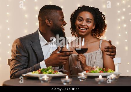 Young afro man and woman having dinner in restaurant Stock Photo
