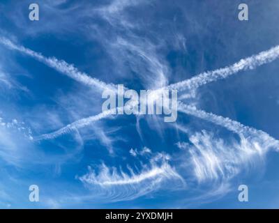 beautiful cirrus clouds with Contrails or vapor trails (homogenitus) forming a cross in the sky Stock Photo