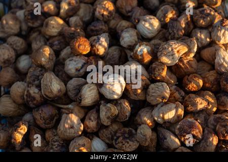 Close-up of sunlit dried figs in warm tones, showcasing organic texture and natural patterns. Concept of healthy food, dried fruits, nutrition, and Me Stock Photo